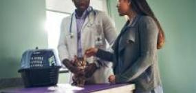 Man in a lab coat speaking to a professional woman