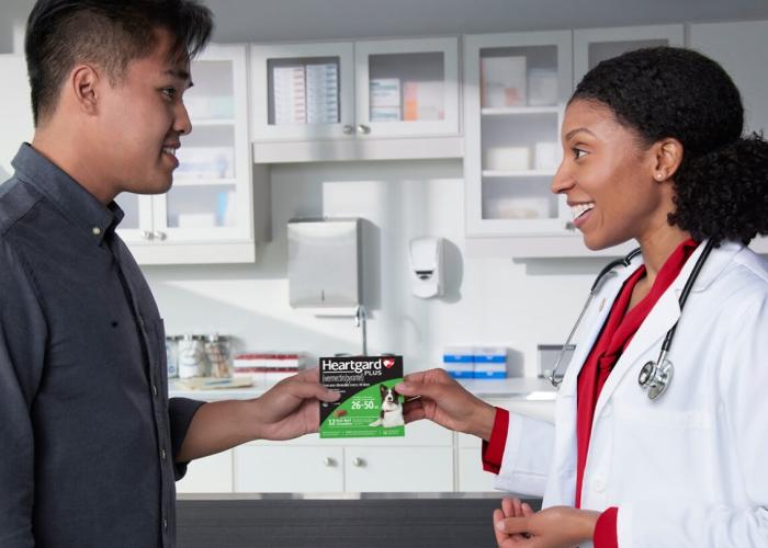 A vet hands a client Heartgard Plus